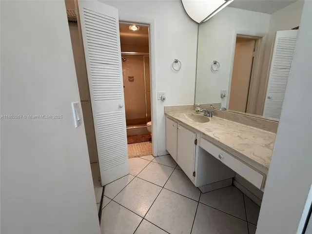 a bathroom with a granite countertop sink a mirror and a shower