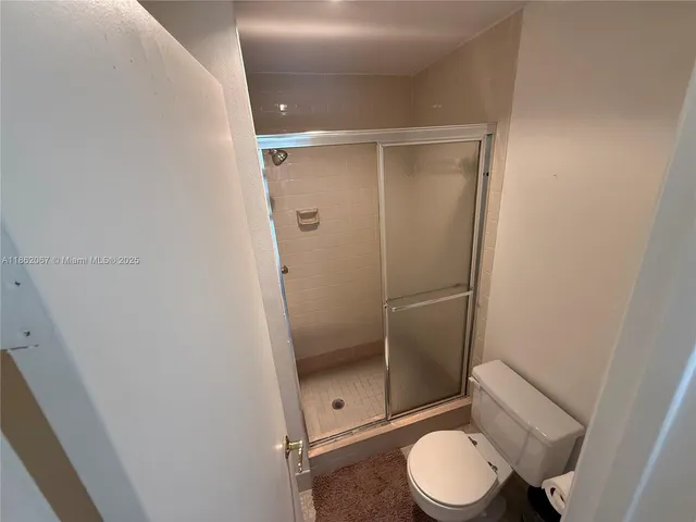 a bathroom with a granite countertop toilet and a shower