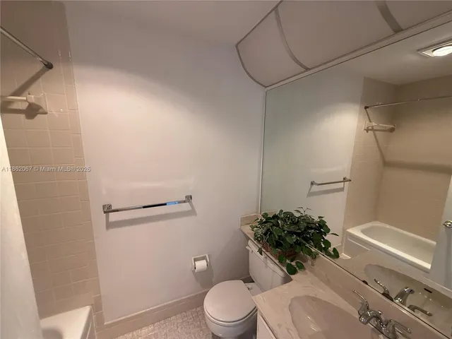 a white toilet sitting next to a bath tub