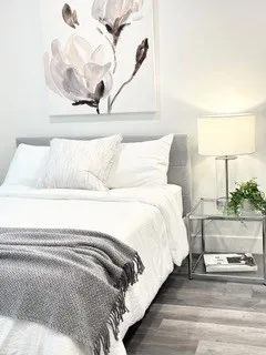 a bed with a white comforter and pillows