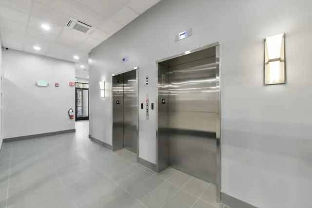 a view of a refrigerator in kitchen and an empty room