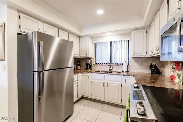 a kitchen with white cabinets and appliances
