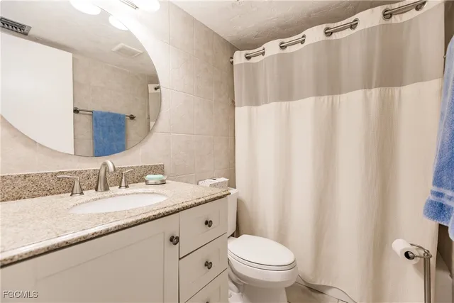 a bedroom with a bed and a flat tv screen on dresser