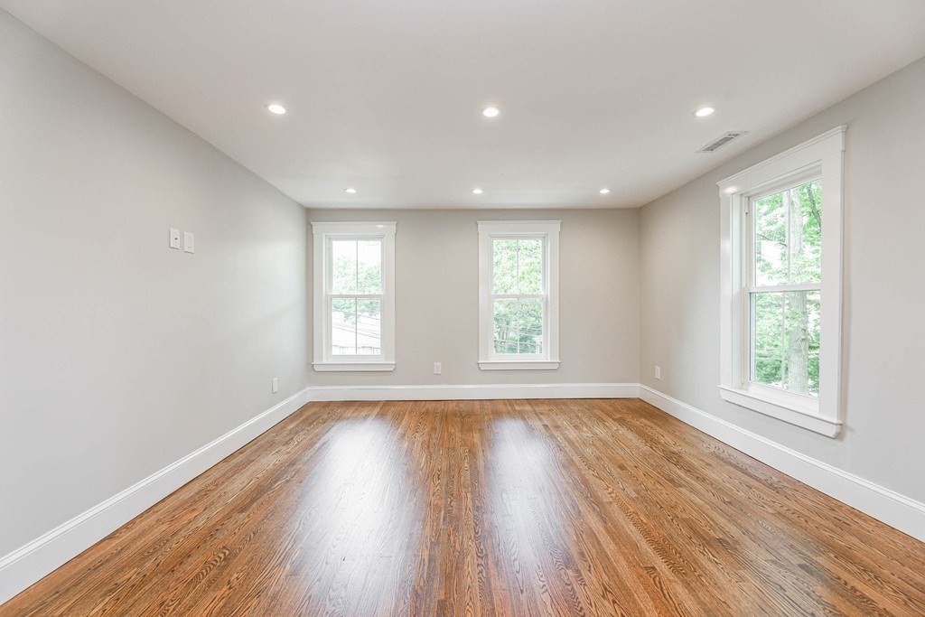 52 Maple Street, Unit 2 Boston, MA 02136 - Photo 11 of 41 an empty room with wooden floor and windows