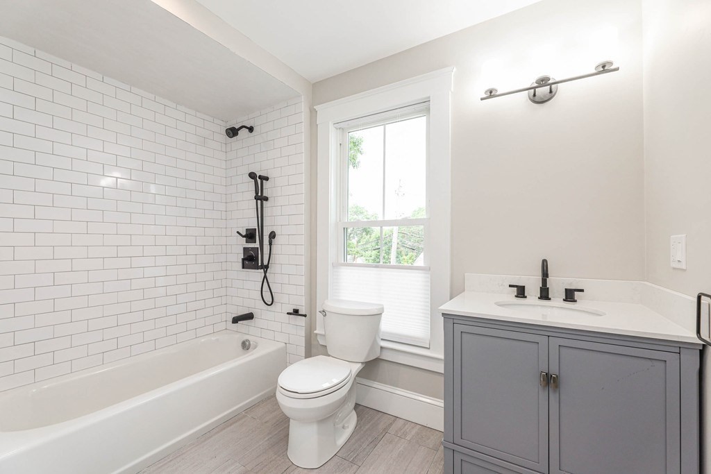 52 Maple Street, Unit 2 Boston, MA 02136 - Photo 14 of 41 a bathroom with a toilet a sink a mirror a bathtub and shower