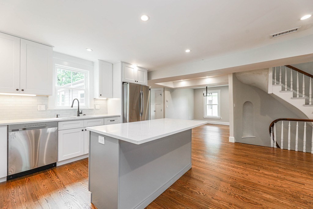 52 Maple Street, Unit 2 Boston, MA 02136 - Photo 2 of 41 a large kitchen with kitchen island a sink wooden floor and a refrigerator
