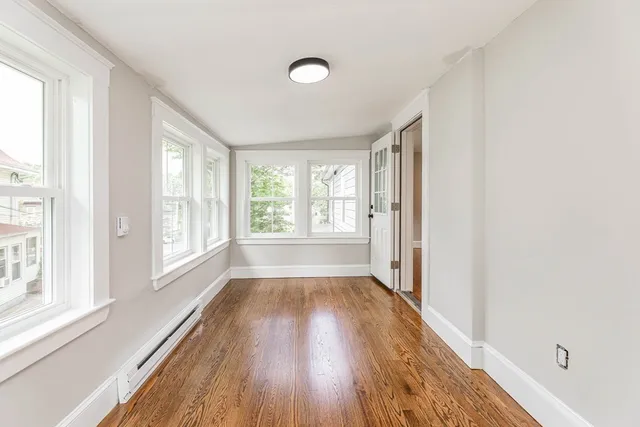 a view of a room with wooden floor and a window
