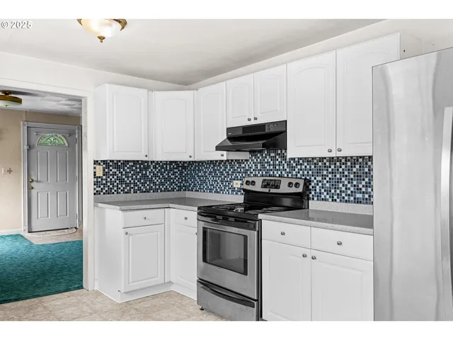 a kitchen with white cabinets and appliances