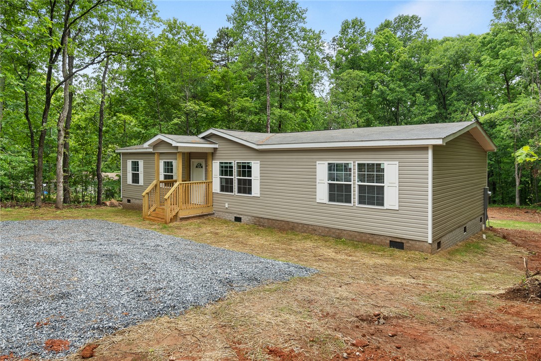 419 Austin Drive Anderson, SC 29624 - Photo 3 of 36 This charming residence is nestled amidst a lush green backdrop, offering a peaceful retreat.