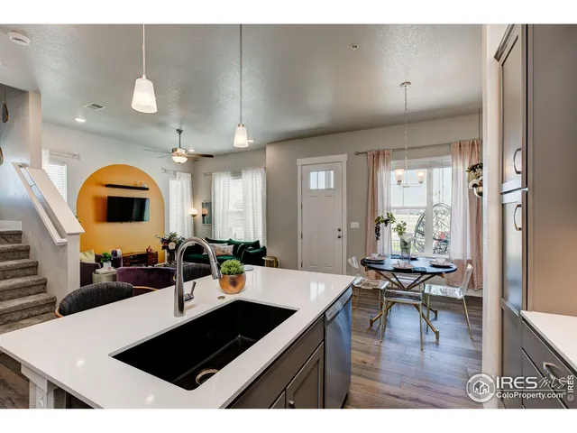 a living room with stainless steel appliances kitchen island a table and chairs