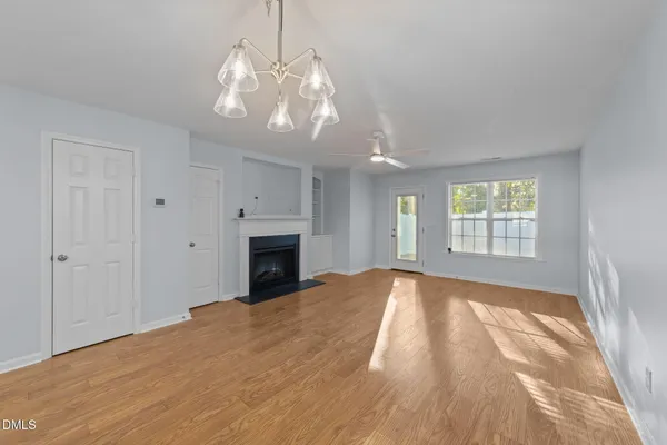 a view of an empty room with a fireplace and a window