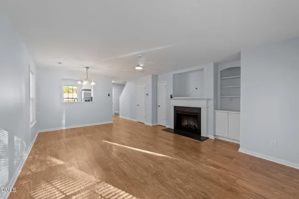 a view of an empty room with window and fireplace