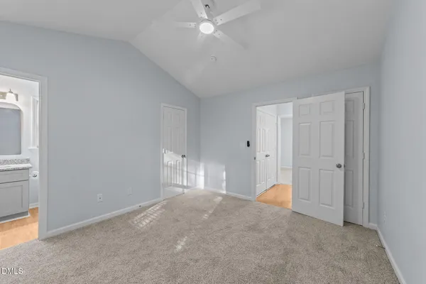 a view of an empty room with closet and a window