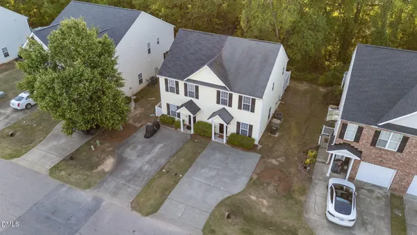 an aerial view of a house with a yard and large tree
