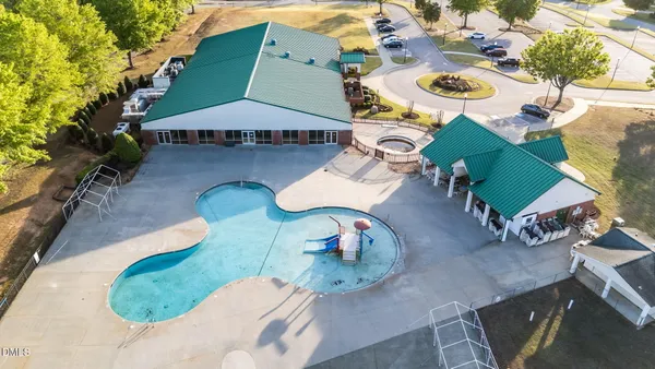 an aerial view of a house with swimming pool and a yard