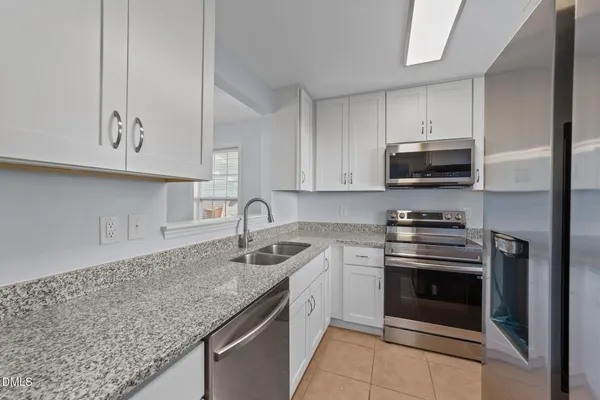 a kitchen with stainless steel appliances granite countertop a sink stove and microwave