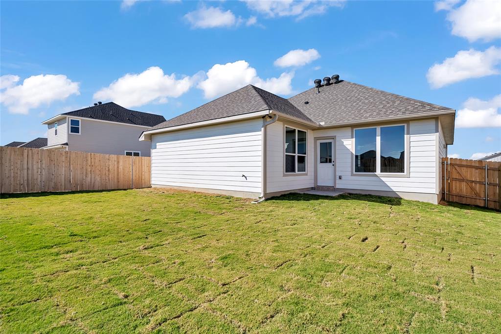 262 Boatright Boulevard Jarrell, TX 76537 - Photo 26 of 30 Back of house with a fenced backyard, roof with shingles, and a patio area