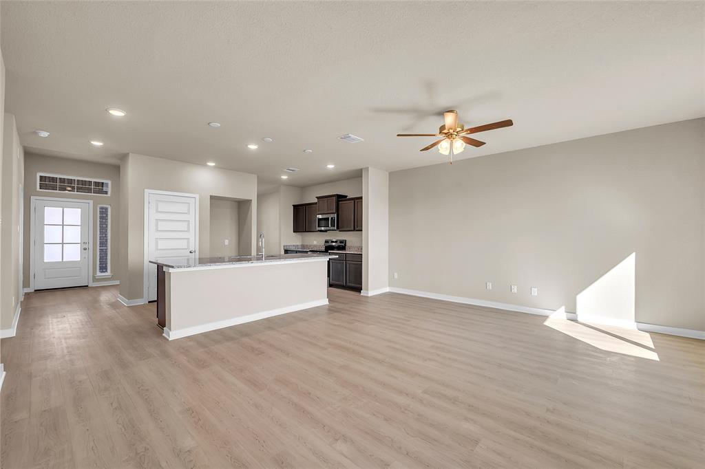 262 Boatright Boulevard Jarrell, TX 76537 - Photo 28 of 30 Kitchen featuring open floor plan, recessed lighting, a center island with sink, dark brown cabinetry, and light wood finished floors
