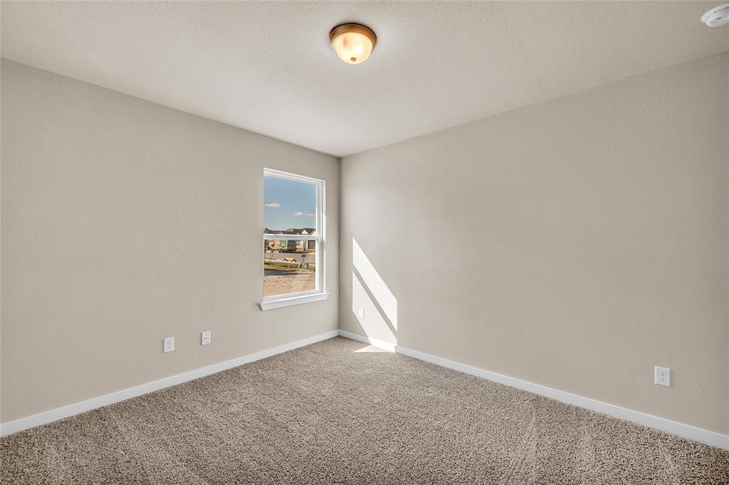 262 Boatright Boulevard Jarrell, TX 76537 - Photo 7 of 30 Empty room featuring carpet, a smoke detector, and a textured ceiling