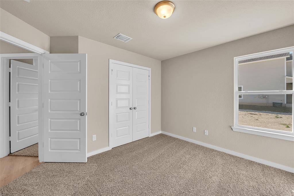 262 Boatright Boulevard Jarrell, TX 76537 - Photo 8 of 30 Unfurnished bedroom featuring light carpet, a closet, and a textured ceiling