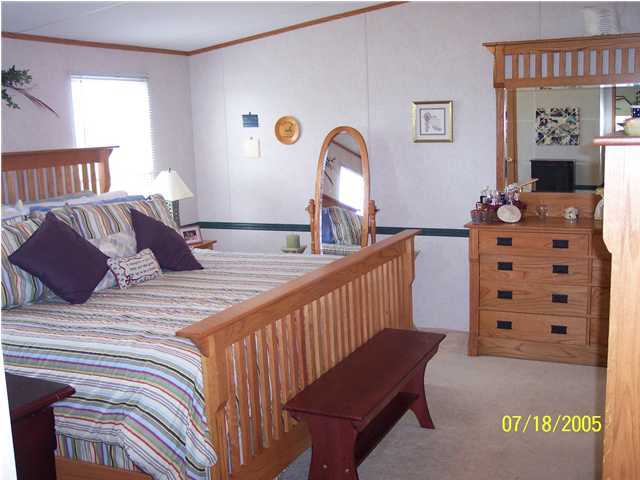 5097 Keyser Mill Road Baker, FL 32531 - Photo 4 of 10 a view of a bedroom with furniture and chandelier