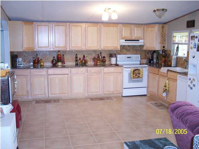5097 Keyser Mill Road Baker, FL 32531 - Photo 9 of 10 a kitchen with stainless steel appliances granite countertop a stove a sink and white cabinets