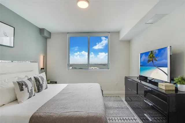 a bedroom with a bed and a flat screen tv