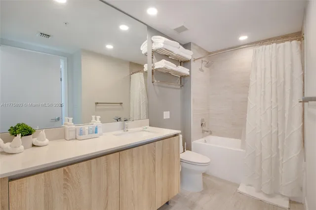 a bathroom with a granite countertop sink a toilet and shower
