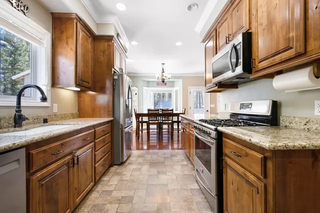 a kitchen with stainless steel appliances granite countertop a sink stove and cabinets