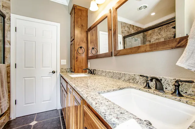a bathroom with a granite countertop sink and a mirror