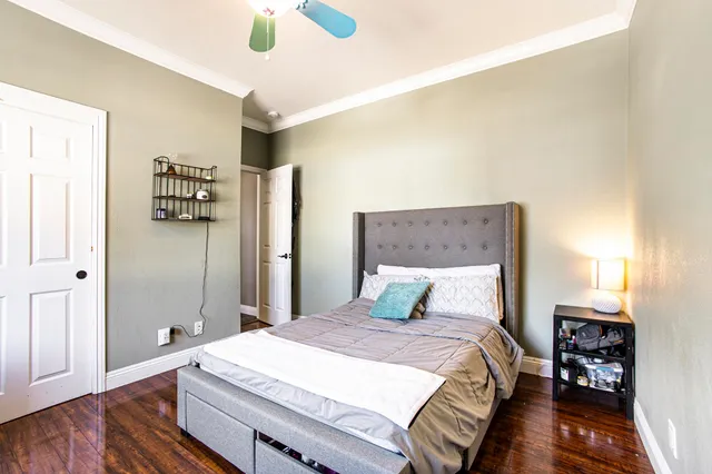 a bedroom with a bed and wooden floor