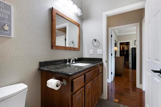 a bathroom with a granite countertop sink a toilet and a mirror