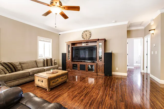 a living room with furniture a flat screen tv and a chandelier