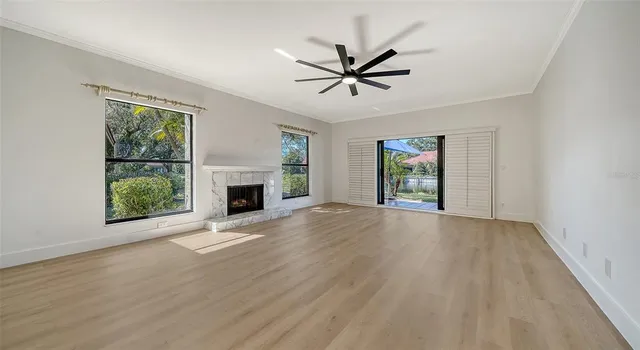 a view of empty room with fireplace and wooden floor