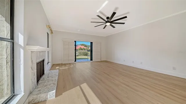a view of an empty room with window and fire place