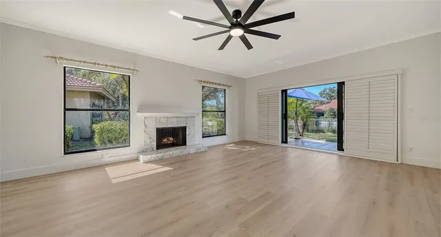 wooden floor fireplace and windows in an empty room