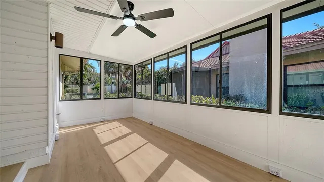 a view of empty room with wooden floor and fan