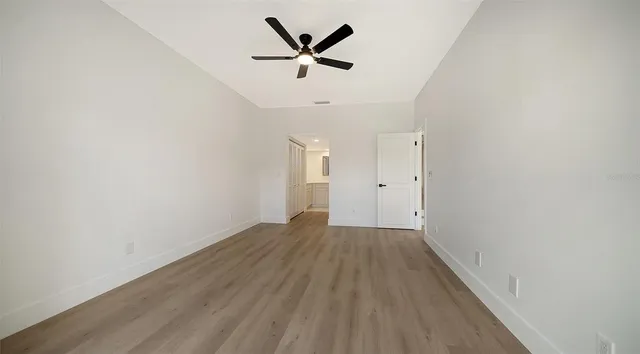 an empty room with fan and windows