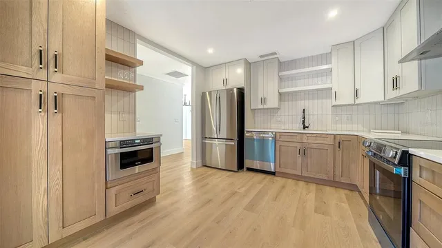 a kitchen with stainless steel appliances a refrigerator stove and sink