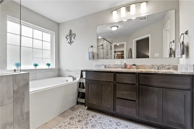 a bathroom with a sink double vanity mirror and bathtub