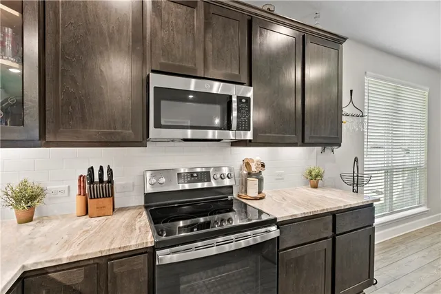 a kitchen with stainless steel appliances a stove microwave and sink