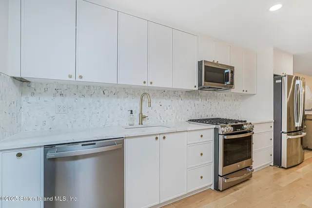a kitchen with stainless steel appliances a refrigerator and a stove top oven