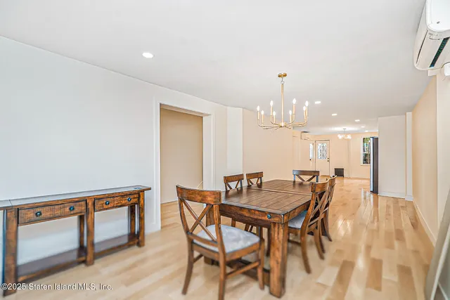 a kitchen with stainless steel appliances kitchen island granite countertop a stove a sink a refrigerator and white cabinets with wooden floor