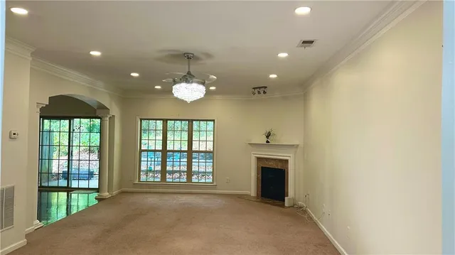 a view of an empty room with a fireplace and a window
