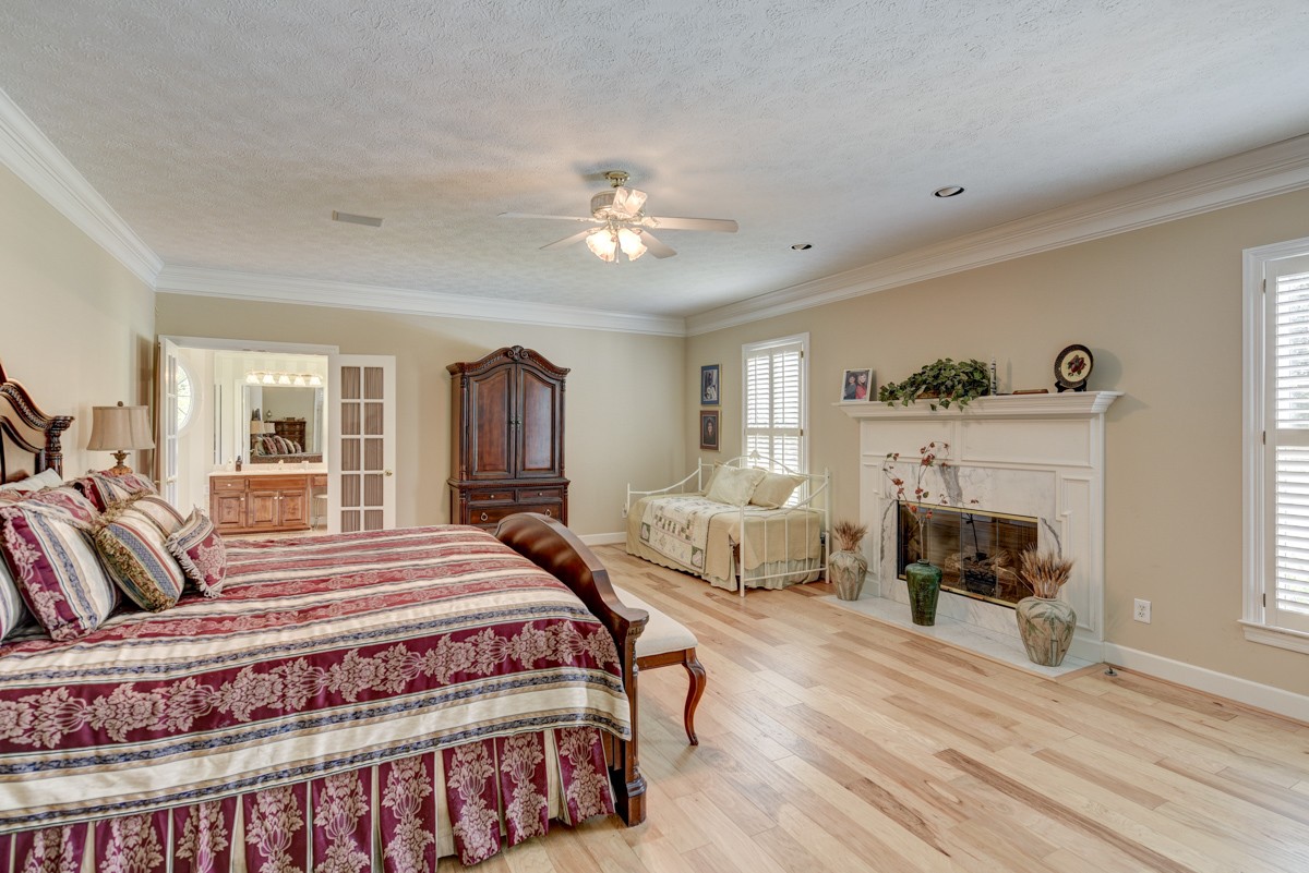 519 Maple Hill Road Lebanon, TN 37087 - Photo 23 of 49 a bedroom with a large bed and a fireplace