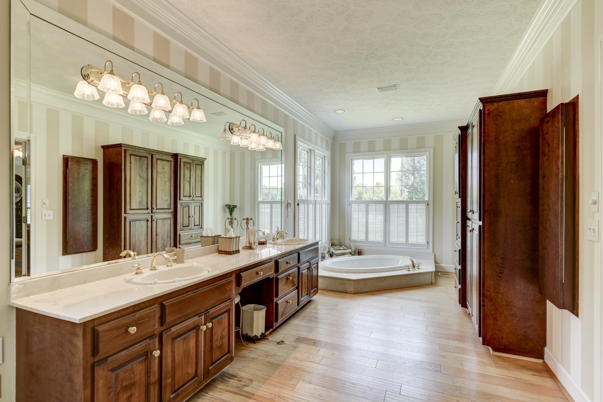 519 Maple Hill Road Lebanon, TN 37087 - Photo 24 of 49 a bathroom with a tub a double vanity sink and a large mirror