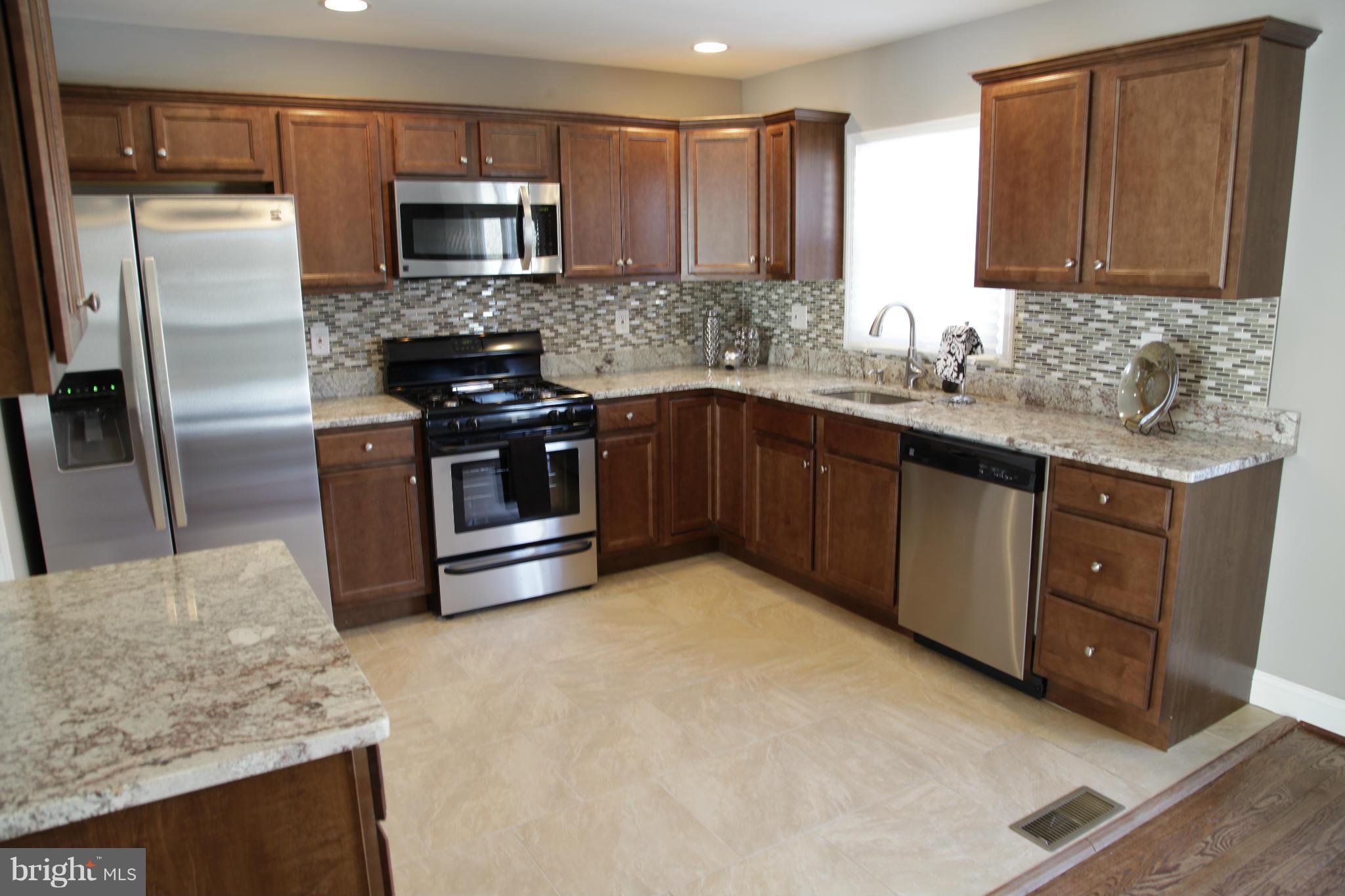 3344 Ripple Road Windsor Mill, MD 21244 - Photo 4 of 30 a kitchen with stainless steel appliances granite countertop a stove a sink and a refrigerator