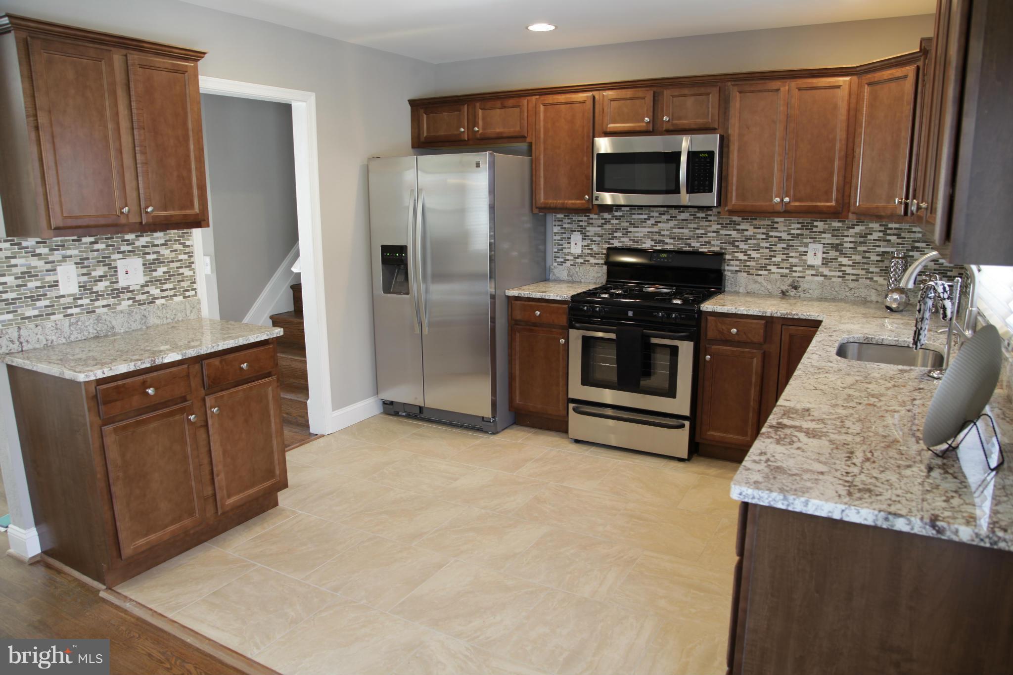 3344 Ripple Road Windsor Mill, MD 21244 - Photo 5 of 30 a kitchen with stainless steel appliances granite countertop a refrigerator stove and microwave