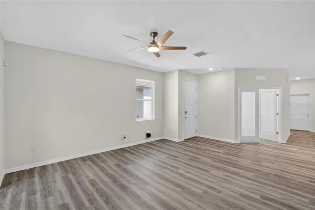 a view of an empty room with wooden floor