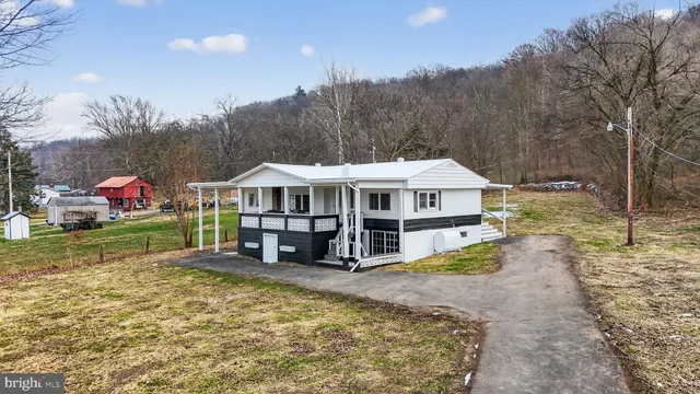 a view of a house with a big yard and large trees